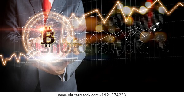 Businessman with Bitcoin currency and gold market\
exchange graphs. Stock market\
concept