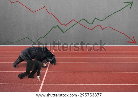 Businessman and black bear are ready to race on running track, with two trend lines drawn on concrete wall background.