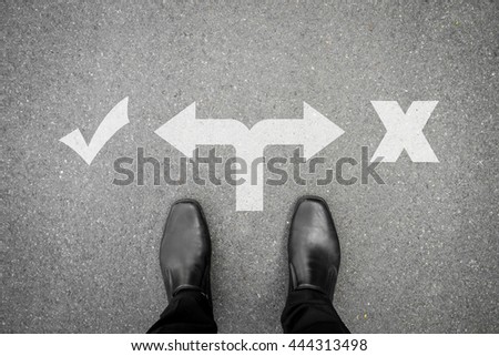 Businessman in black shoes standing at the crossroad making decision which way to go - right or wrong. true or fault. correct or not correct.