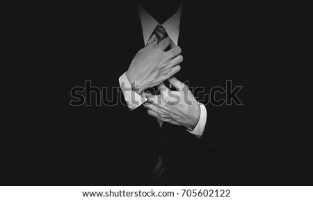 Businessman in black suit on black background, black and white