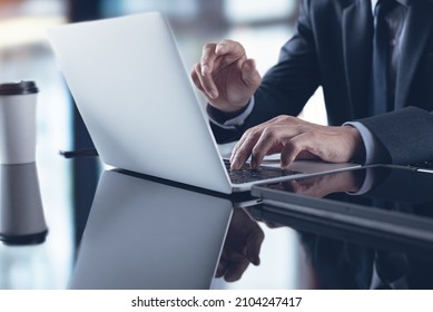 Businessman In Black Suit Working On Laptop Computer At Modern Office. Business Man Have A Discussion During Zoom Online Meeting, Video Conference Using Online Meeting App With Digital Tablet On Table