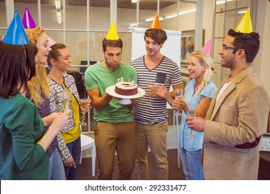 Businessman Blowing Candles On Her Birthday Cake In The Office