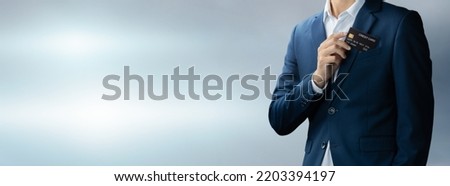 Businessman in blue suit put or take out credit card in pocket with copy space background, Technology digital future of business finance and payment online shopping concept, Handsome young in close up