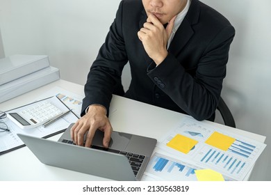 Businessman boss in suit is thinking and analysis of investments in new business from chart during to typing new idea for business project and financial data while sitting to working in office - Shutterstock ID 2130563819