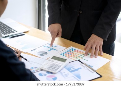 GeschäftsmannsChef des Teams zeigt auf Graph und Diagramm, um das Ziel der Tabelle für eine Kraft zu den Mitarbeitern zu erreichen, hart über das Marketingziel durch Verwendung von Daten arbeiten, um die Daten 
