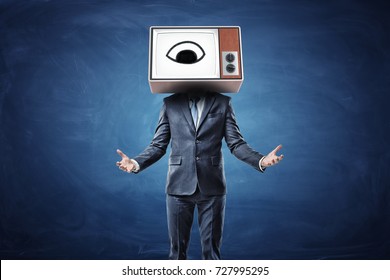 A Businessman With Both Arms In Front Of Him Palms Up And A Head Replaces By A TV Box With An Eye On A Screen. Big Brother. Corporate Control. Supervision At Work.