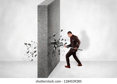 Businessman Breaking Wall Of Obstacle By Hitting It With Sledgehammer. Business Challenge Conquering Adversity Concept