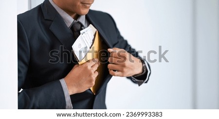 Businessman briefcase document envelope with dollar banknotes on white background. businessman putting illegal secret agreement money in his jacket. corruption, bribery, crime and embezzle concept