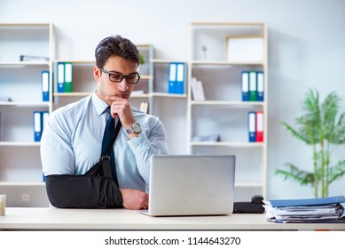 Businessman With Broken Arm Working In Office