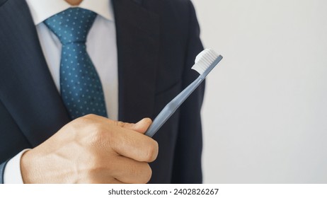Businessman brushing his teeth. I have a toothbrush with toothpaste on it.