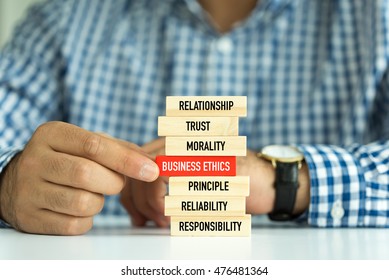 Businessman Building BUSINESS ETHICS Concept with Wooden Blocks