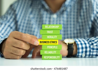 Businessman Building BUSINESS ETHICS Concept with Wooden Blocks