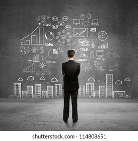 businessman with business plan concept on wall