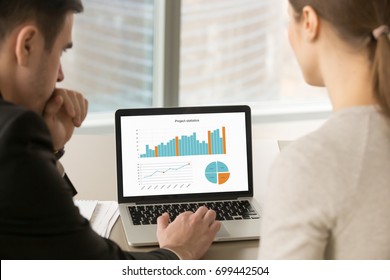 Businessman And Businesswoman Analyzing Project Statistics Data On Laptop Screen, Partners Discussing Infographic Information About Company Growth, Annual Report Analysis, Close Up Rear View