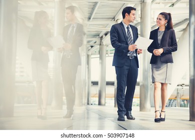 Businessman and businesswoman discussing work while walking, vintage tone effect - Powered by Shutterstock