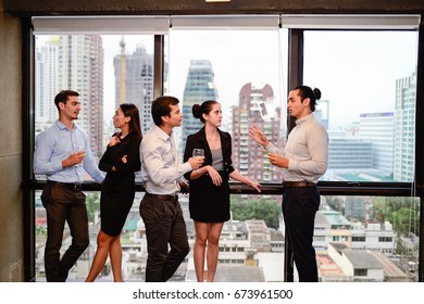 businessman and businesswoman are drinking champagne talking and smiling while celebrating in office, successful business concept. - Shutterstock ID 673961500