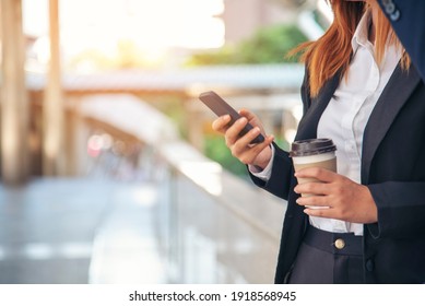 Businessman Businesswoman Drinking Coffee In Town Using Smartphone Outside Office Modern City. Hands Holding Take Away Coffee Cup And Smart Phone Talking Together Business Partner With Cup Of Coffee