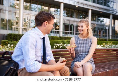Businessman And Businesswoman Eating Lunch Outside Office