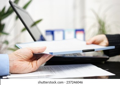 businessman and businesswoman are exchanging document or contract - Powered by Shutterstock