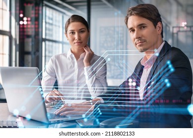 Businessman and businesswoman in formal wear working together to optimize business process by applying new technologies. Hi tech holograms over modern office background with panoramic windows