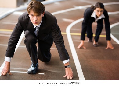 Businessman and businesswoman lined up getting ready for race in business - Powered by Shutterstock