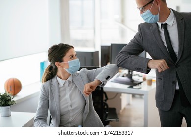 Businessman and businesswoman with medical mask in office. Greetings in Covid-19 time. - Powered by Shutterstock