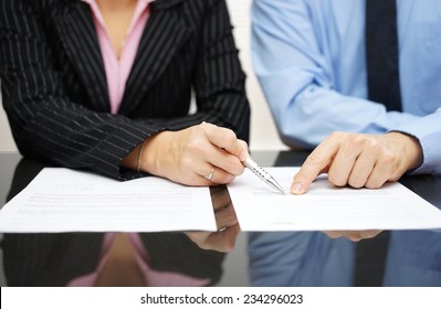 businessman and businesswoman are pointing to article of the treaty