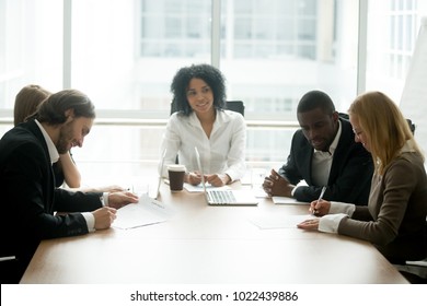 Businessman and businesswoman signing contracts at group multiracial meeting, two smiling male and female new partners making deal after successful negotiations putting signature on business papers