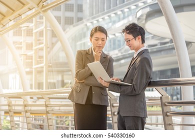 Businessman And Businesswoman Using Digital Laptop Computer At Outside Office, Success And Happiness Team Concept.