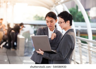 Businessman And Businesswoman Using Digital Laptop Computer At Outside Office, Success And Happiness Team Concept.