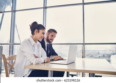 Businessman And Businesswoman Working With Laptop At Modern Office