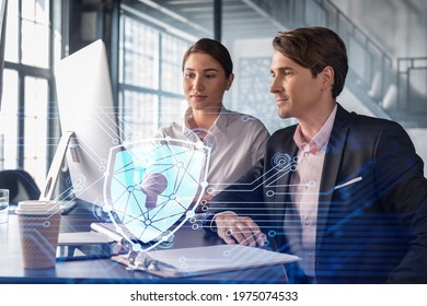 Businessman And Businesswoman Working Together To Protect Clients Confidential Information And Cyber Security. IT Hologram Padlock Icons Over Office Background With Panoramic Windows.