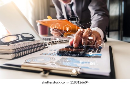Businessman calculates financials with graph paper on the table on the cost of home office in the evening. - Shutterstock ID 1188126604