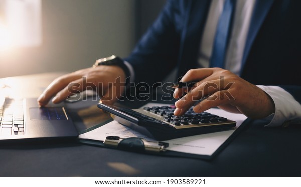 Businessman calculating the financial statement of\
his business. Accounting and\
Tax.