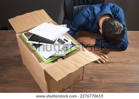 Businessman with a cardboard box and business objects. Job loss. Unemployment