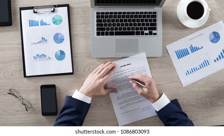 Businessman careful reading living will conditions and signing paper, top view - Shutterstock ID 1086803093