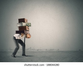Businessman carrying heavy suitcases. concept of difficulty
