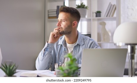 Businessman In Casual Using Laptop In Home Office, Young Adult Man Sitting At Desk In Study Room, Working Online With Computer, Thinking.