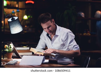 Businessman Caucasian men are working at night. With a laptop, books and documents is on the table. - Shutterstock ID 1086509411