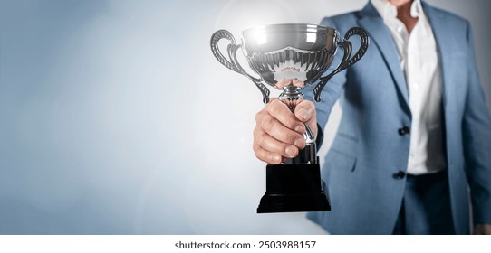 Businessman celebrating with trophy award for success in business or first place sporting championship win - Powered by Shutterstock