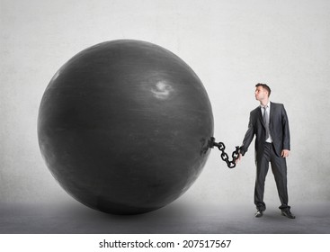 Businessman chained to a large ball