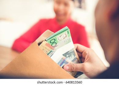 Businessman checking money, Australian dollars, in the envelope