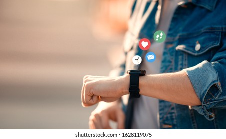 Businessman checking smart watch with colorful application icons. Concept of using smartwatch for health. - Powered by Shutterstock