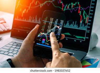 Businessman checking stock market by his smartphone and labtop.Trade and finance concept
