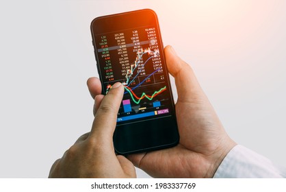 Businessman checking stock market by his smartphone.Trade and finance concept - Shutterstock ID 1983337769