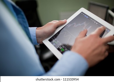 Businessman checking stock market on tablet