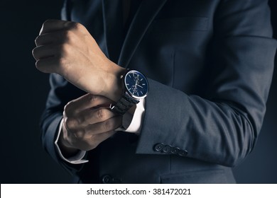 Businessman checking time from watch - Shutterstock ID 381472021