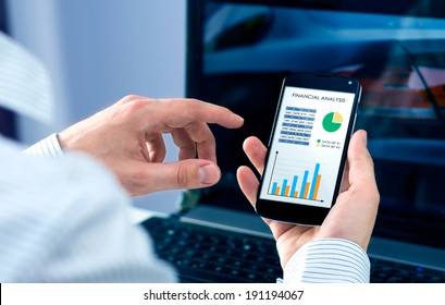 Businessman checks the financial analysis on smartphone - Powered by Shutterstock