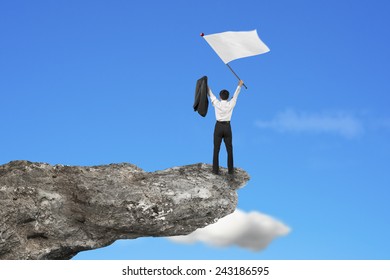 A Businessman Cheering On Cliff Waving Blank White Flag With Natural Sky Cloud Background