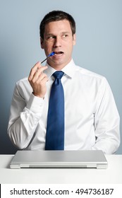 Businessman Chewing Pen At Desk